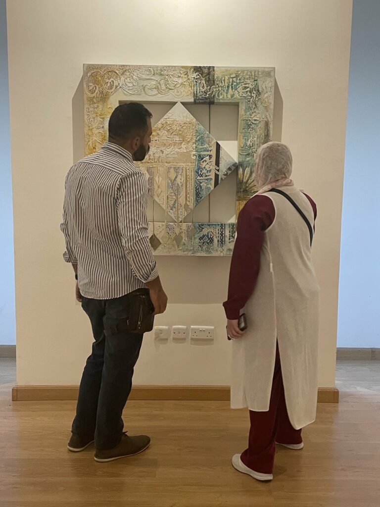 Two people view artwork at the Jordan National Gallery of Fine Arts